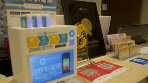 Een etalage met een smartphone-oplaadstation, promotiemateriaal en een QR-code.
