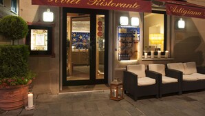 Hotellin sisäänkäynti, jonka yläpuolella on punainen markiisi, jossa lukee ”Hotel Ristorante” ja ”Astigiana”.