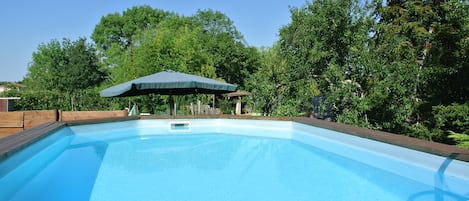Una piscina al aire libre, sillones reclinables de piscina