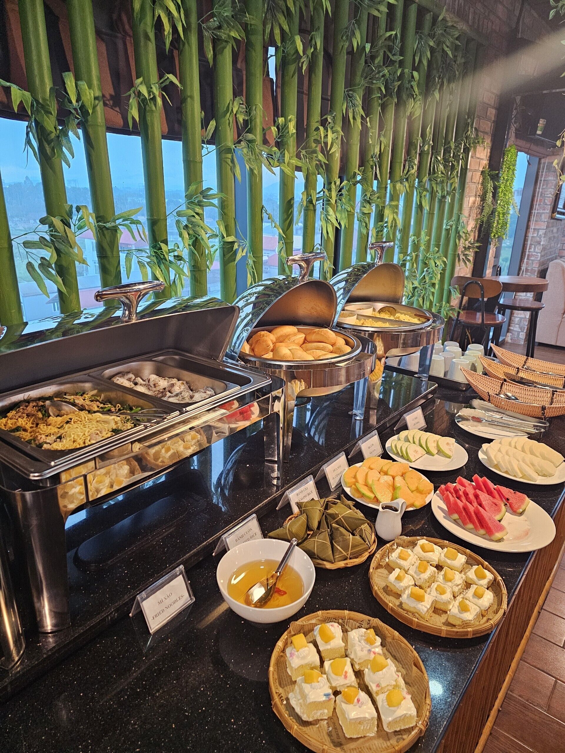 Un bufé con diferentes opciones de comida, como fideos, dumplings y frutas.
