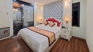 Un dormitorio de hotel con una cama grande, un armario, un espejo y una ventana.