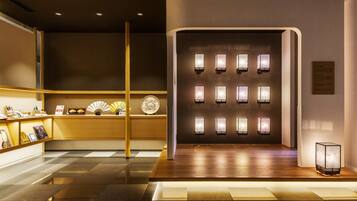 Un moderno vestíbulo de hotel con piso a cuadros, una recepción y una pared de faroles iluminados.