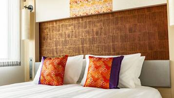 A hotel room with a wooden headboard, a bed with white linens, and decorative pillows.