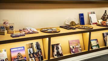 A reception desk with a display of books, a fan, and a bottle.