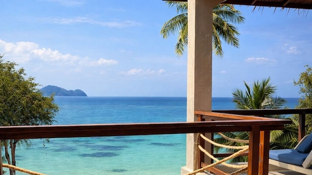 A balcony with a view of the ocean, a rope barrier, and a yellow table. - Baan Jai Dee Beach Front Hotel (Ko Pha-ngan)