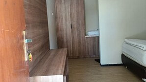Una habitación moderna con un banco de madera, un armario y una cama.