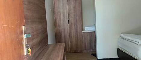 A modern room with a wooden bench, a wardrobe, and a bed.