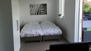 A bedroom with a bed, a zebra print artwork on the wall, and a view of the outside patio.