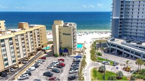 A hotel with a pool, beach view, and parking lot. - Modern True Blue: Gulf Shores Escape w/ Deeded Beach Access, Pool & Beach Gear! (Gulf Shores)