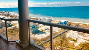 Ein Balkon mit Blick auf Strand und Meer.