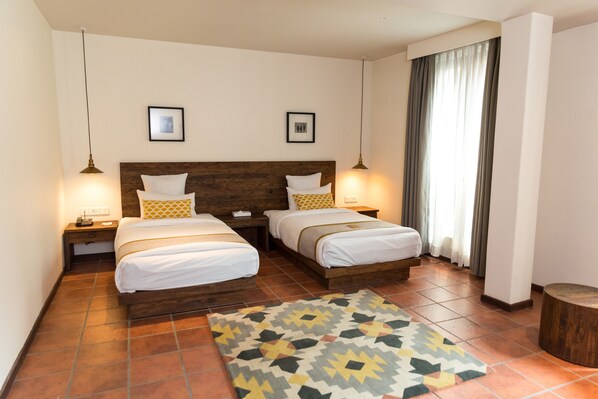 A double room with two beds, a patterned rug, and a wooden headboard. - Hotel Roadhouse, Thamel, Kathmandu- Contemporary Boutique (Kathmandu)