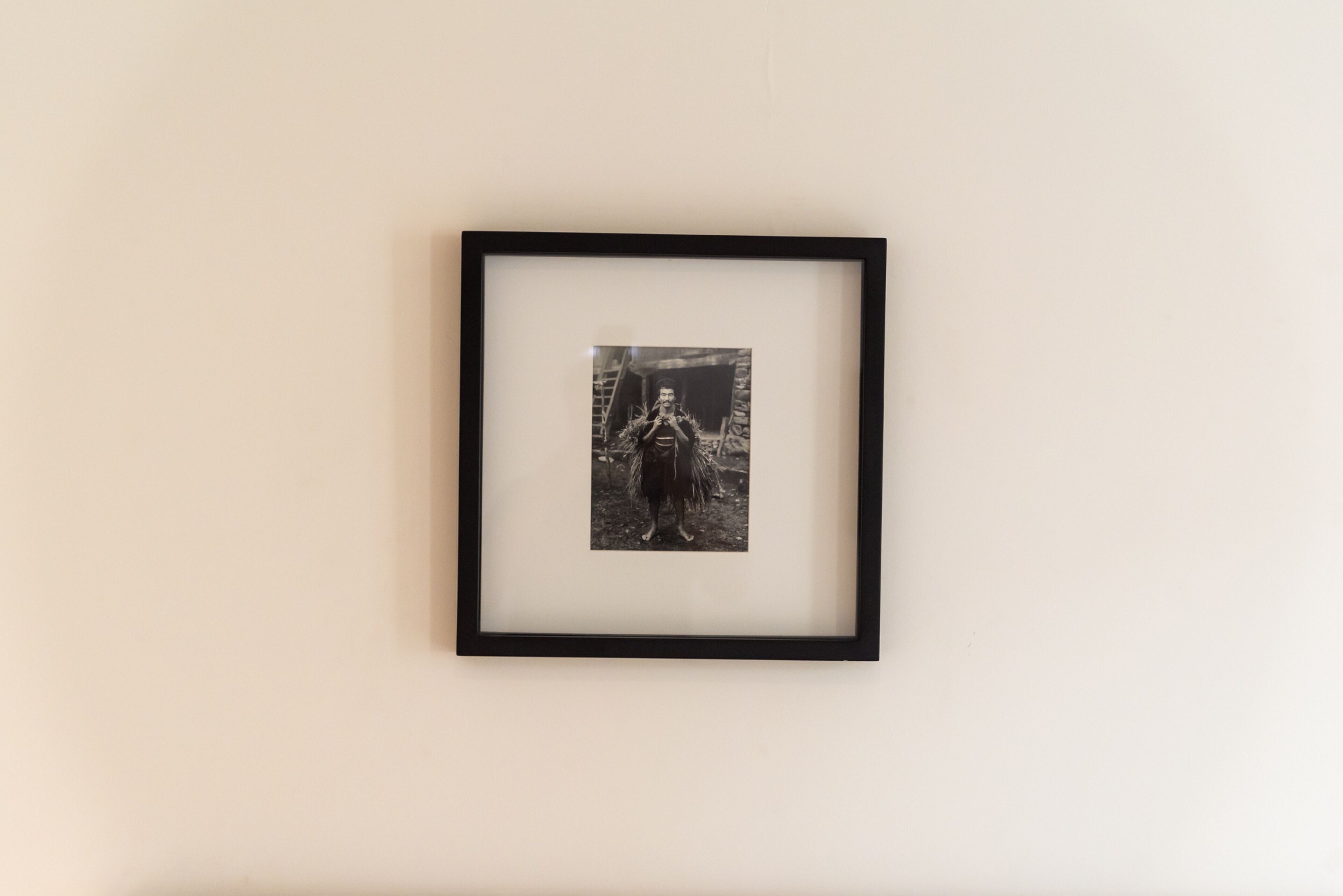 A framed black and white photograph on a plain wall.