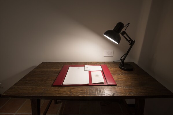 A wooden table with a desk lamp, papers, and a red folder. - Hotel Roadhouse, Thamel, Kathmandu- Contemporary Boutique (Kathmandu)