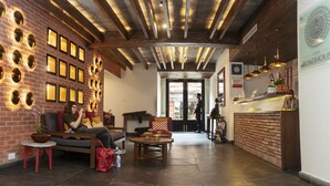 A hotel lobby with a brick wall, wooden ceiling beams, and a reception desk. - Hotel Roadhouse, Thamel, Kathmandu- Contemporary Boutique (Kathmandu)