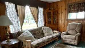 A cozy living room with a sofa, armchair, and a cabinet. - FISHING AND FAMILY FRIENDLY- NOTHING FANCY (Linesville)