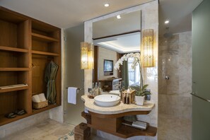 Une salle de bain avec un meuble-lavabo en bois, un grand miroir et un espace douche.