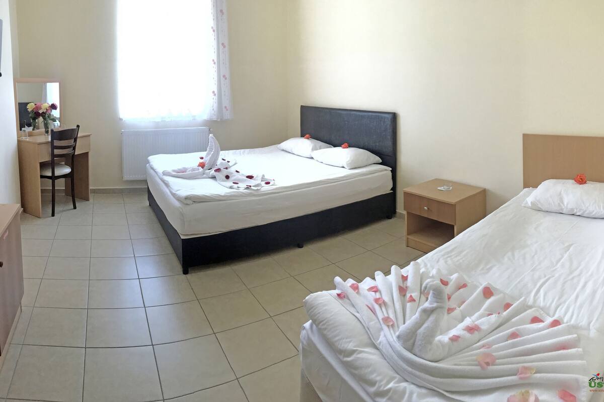 Une chambre d’hôtel avec deux lits, un bureau et une chaise.