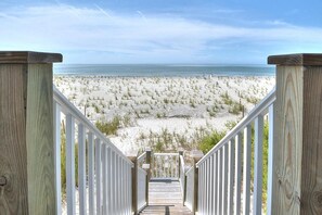 A wooden staircase leading to a beach with a view of the ocean. - Experience oceanfront bliss at Blue Yonder, a spacious 4-bedroom retreat in Oak Island. (Oak Island)