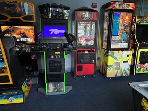 Une rangée de bornes d’arcade proposant des jeux tels que « Global VR », « Photon » et « ALIENS ».