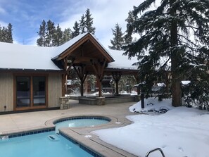 A pool area with a wooden deck, a covered seating area, and snow-covered trees. - 2br 2ba Condo, newly remodeled - 200yds to Lift - 2 Blocks to Downtown (Breckenridge)
