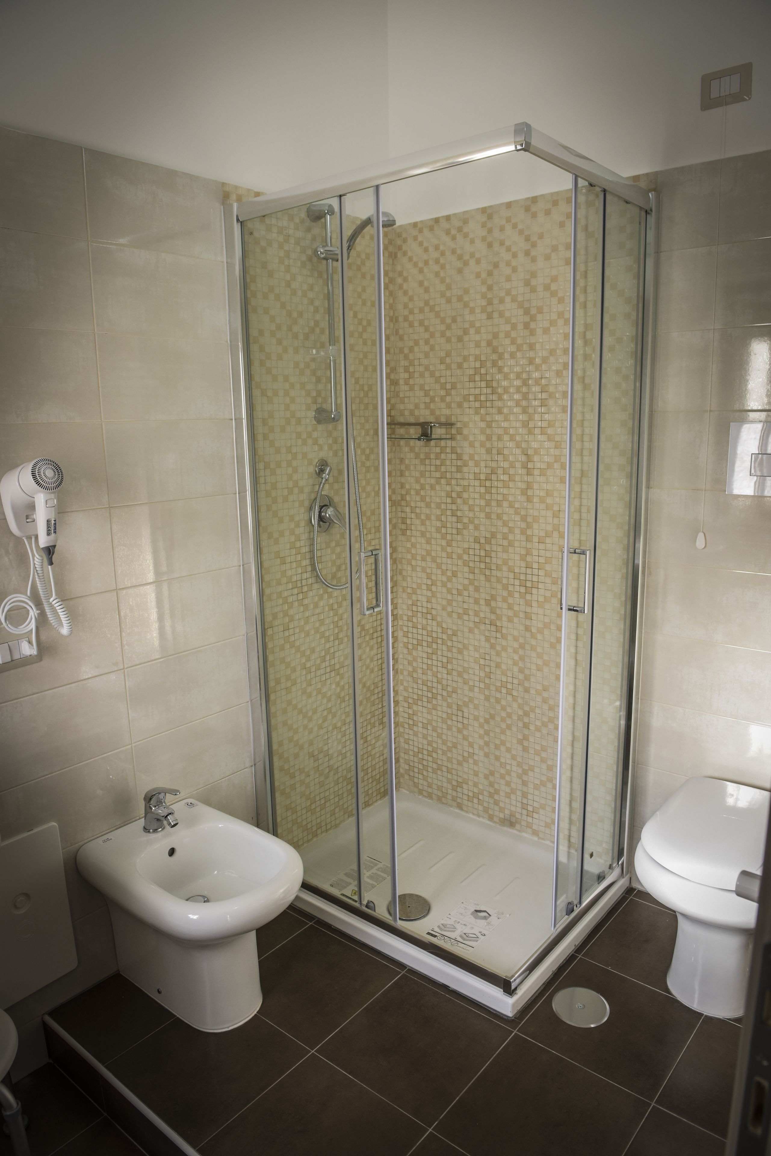 Un baño con ducha de vidrio, un bidé y un inodoro.