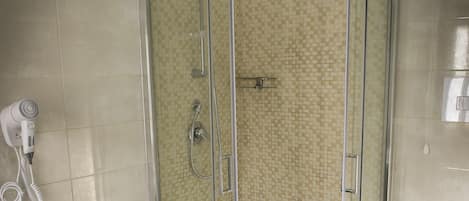 Un baño con ducha de vidrio, un bidé y un inodoro.
