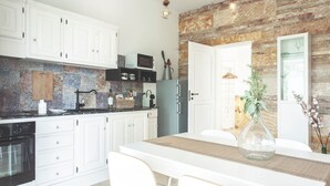A modern kitchen with white cabinets, a built-in microwave, and a refrigerator. - Dimora il Mandorlo (Ostuni)
