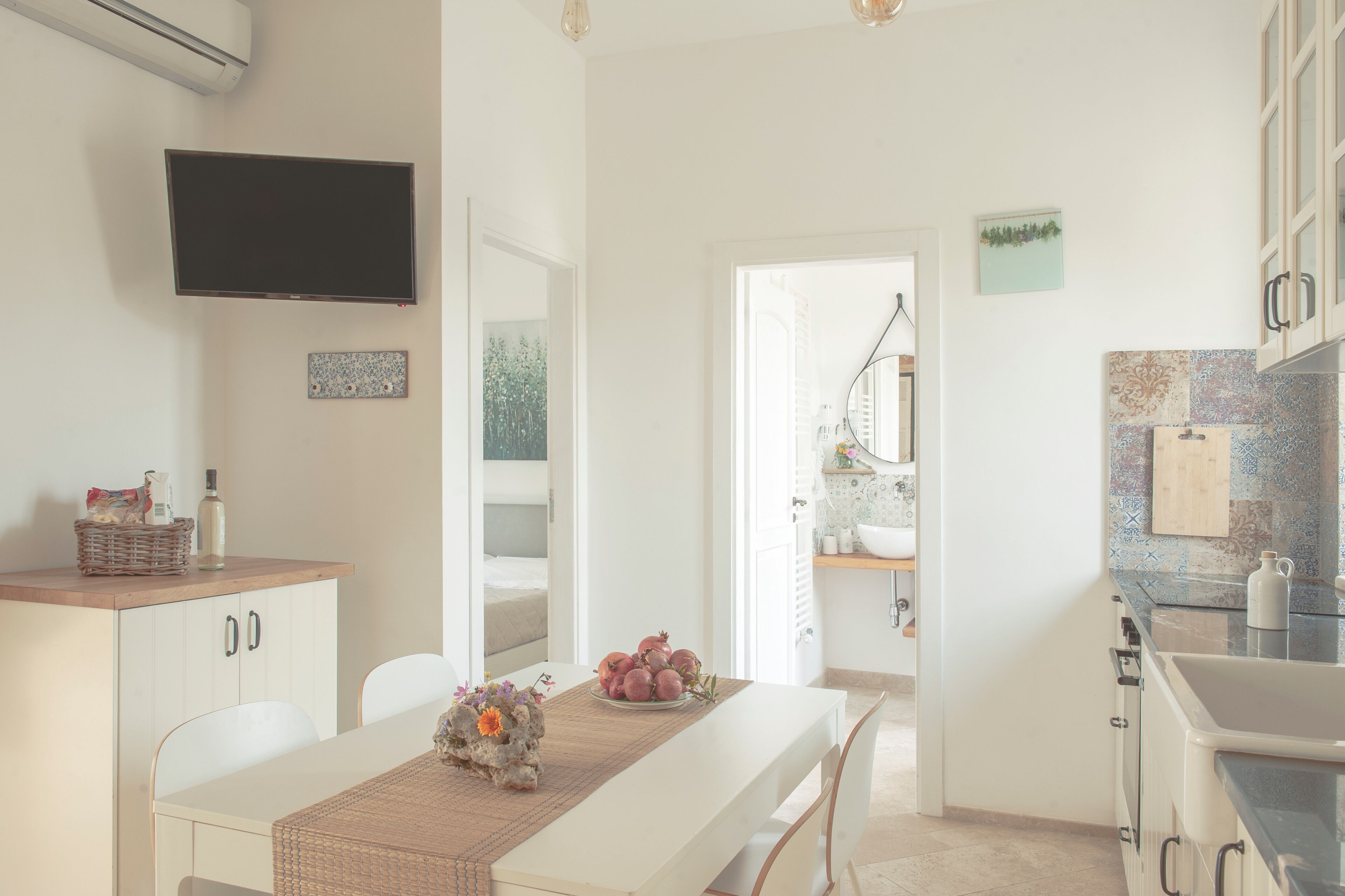 A modern kitchen with white cabinets, a built-in oven, and a large window.