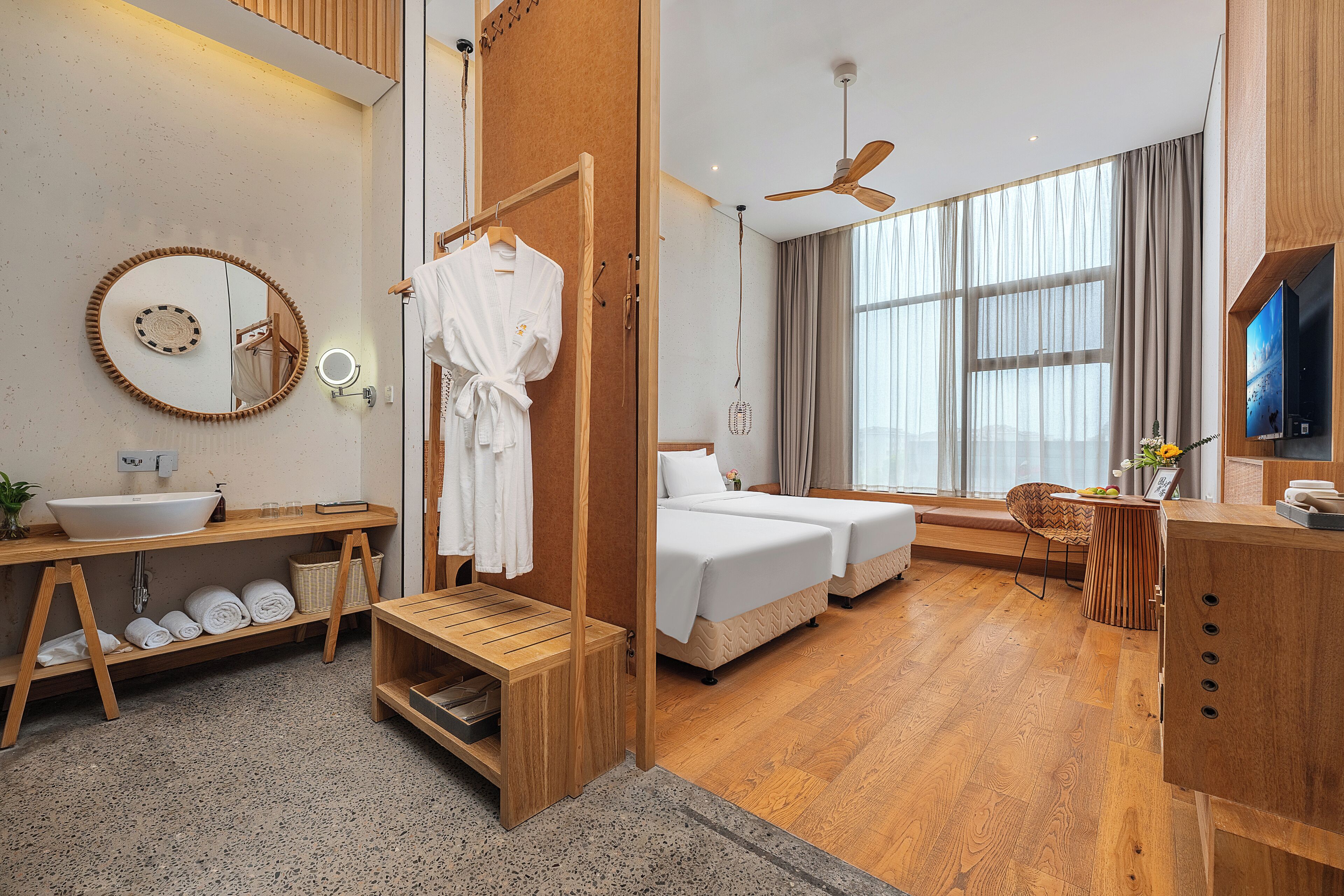 Une chambre d’hôtel moderne, dotée d’un grand miroir, de meubles en bois, d’un lit, d’un bureau et d’une télévision.