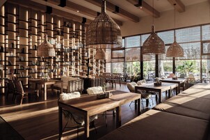 A spacious library with high ceilings, large windows, and modern furniture.
