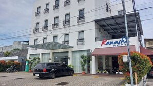 A hotel with a white facade, balconies, and a covered entrance. - Kanasha Islami (Medan)