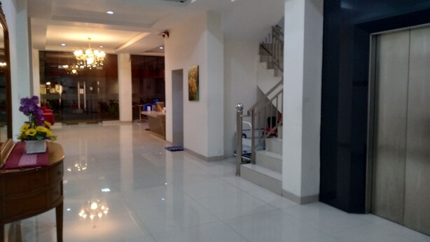 A spacious lobby with a chandelier, a staircase, and a reception desk. - Kanasha Islami (Medan)