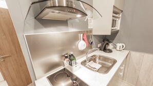 Une cuisine moderne équipée d’appareils électroménagers en acier inoxydable, d’un four encastré et d’un évier.