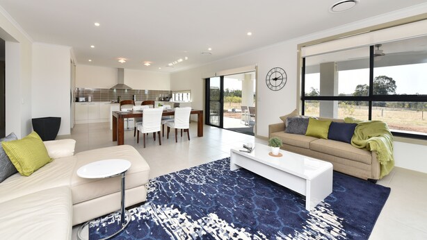 Uma sala de estar moderna com um sofá, mesa de centro e vista para a cozinha e sala de jantar.