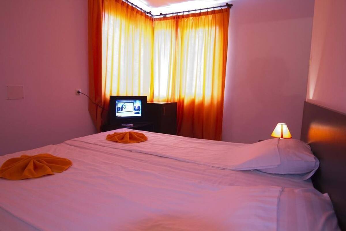 Escritorio, cortinas blackout y tabla de planchar con plancha