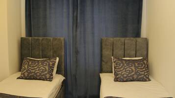 Une chambre d’hôtel avec deux lits, chacun doté d’une tête de lit et d’une couvre-lit à motifs.