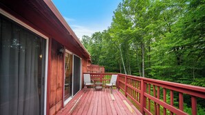 A wooden deck with red railings, two chairs, and a table. - Evergreen Valley Inn by Coolvacay (Stoneham)