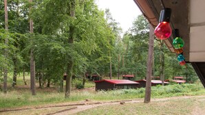 Ein bewaldetes Gebiet mit einem Feldweg, der zu kleinen Hütten mit roten Dächern führt.