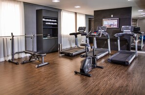 Un gimnasio con cintas de correr, elíptica y remo.