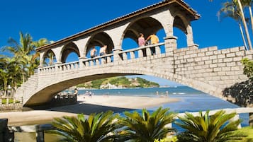 Uma ponte de pedra com arcos sobre uma praia.