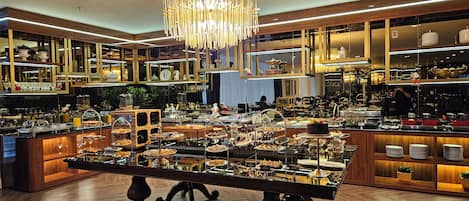 Un área de bufé con diversas opciones de comida y una lámpara decorativa.