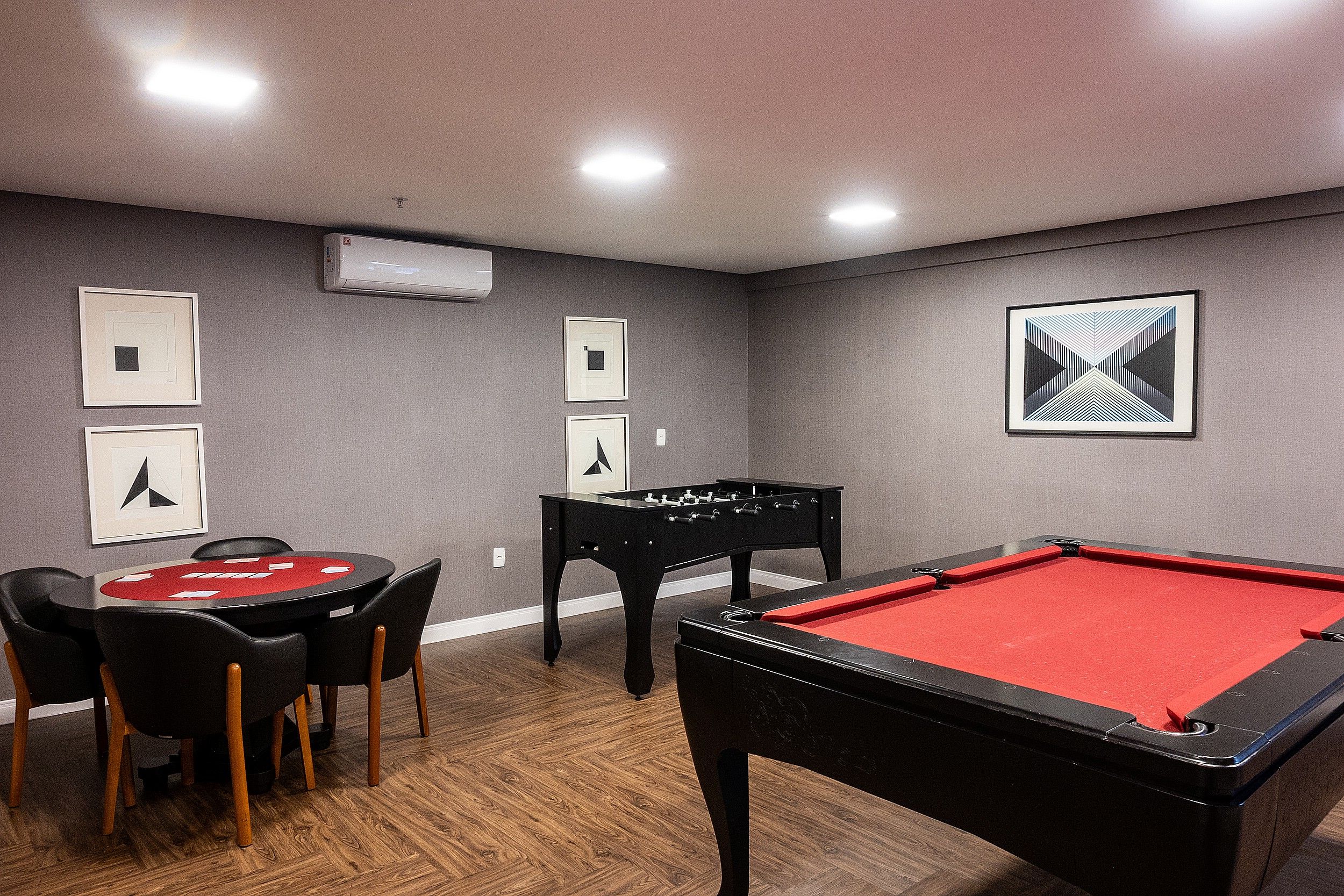 Una sala de billar con mesa de billar, mesa de fútbolín y mesa de póker.