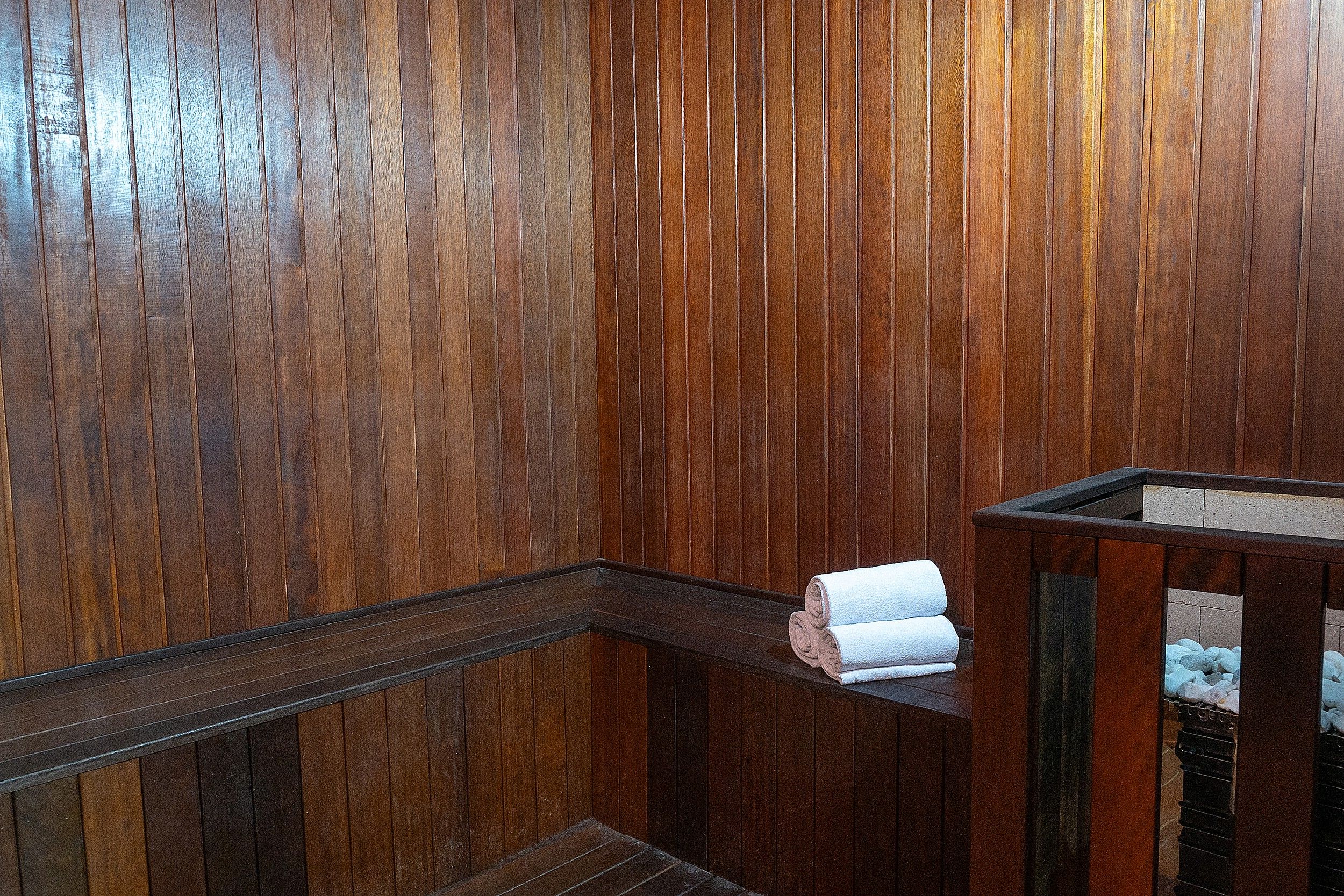 Interior de madera con un banco y una toalla encima.