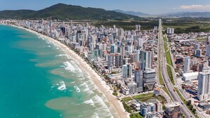 Un paisaje urbano costero con playa, edificios altos y una autopista.