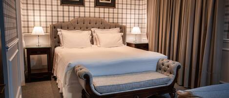 A neatly arranged bedroom with a large bed, two bedside tables with lamps, and a headboard.