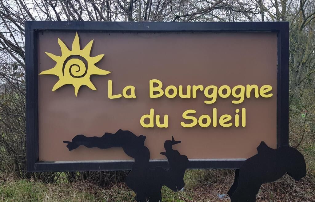 Un letrero con el texto 'La Bourgogne du Soleil' y siluetas de caballos.