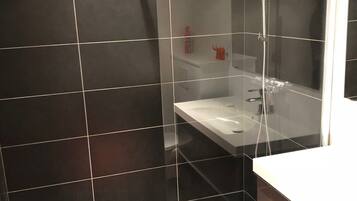 Comfort kamer | Badkamer | Een douche, een regendouche, een haardroger, handdoeken