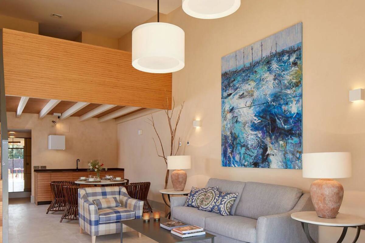 Una sala moderna con un sofá, una mesa de centro y un cuadro en la pared.