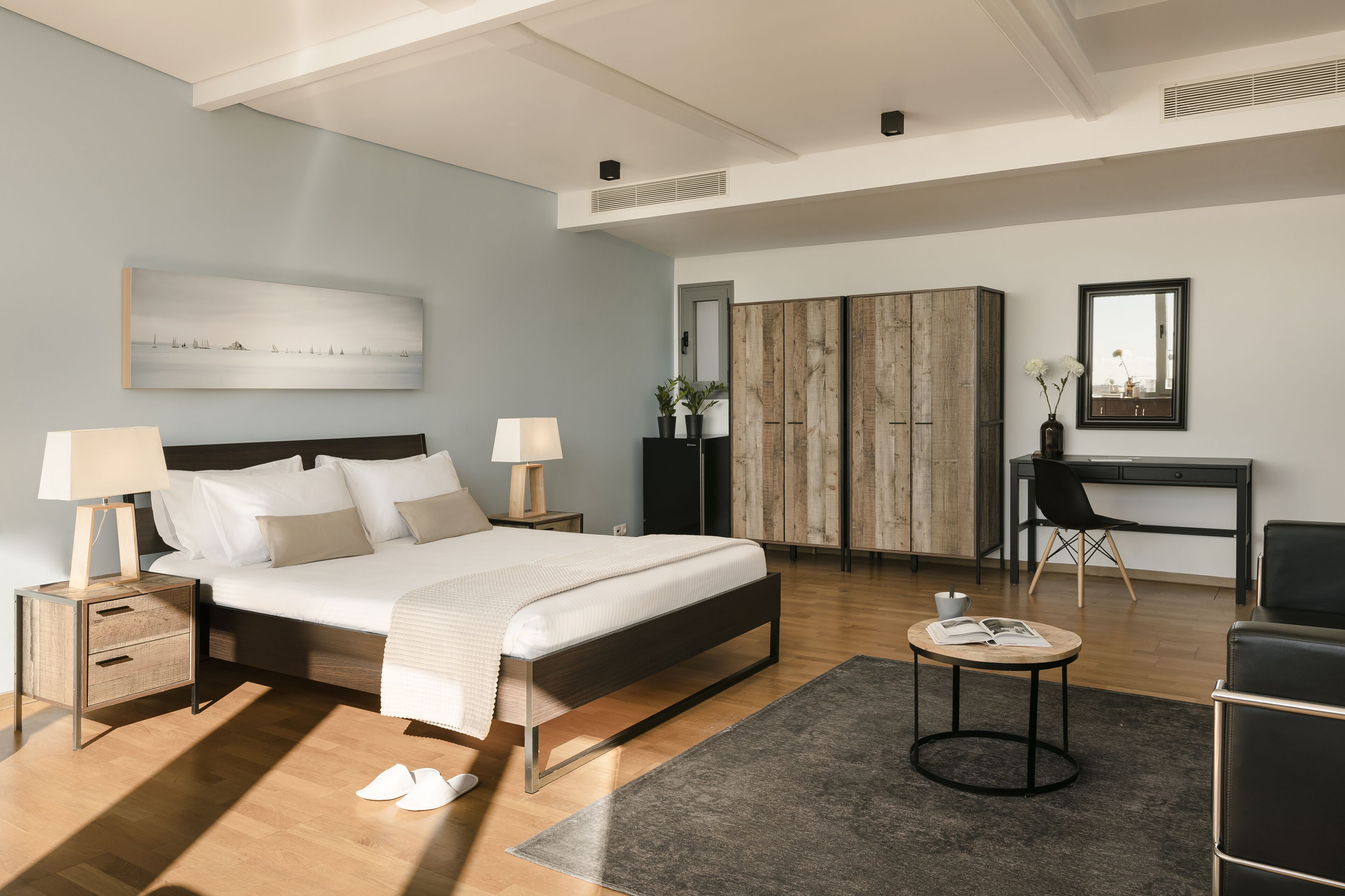 Une chambre moderne avec un grand lit, des tables de chevet, un bureau et une chaise.