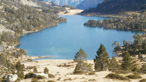 A lake surrounded by mountains and sparse vegetation. - Le Barbajou (Aragnouet)
